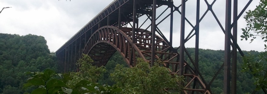The New River Gorge Bridge stretches over the verdant New River Gorge, West Virginia, on a cloudy day.